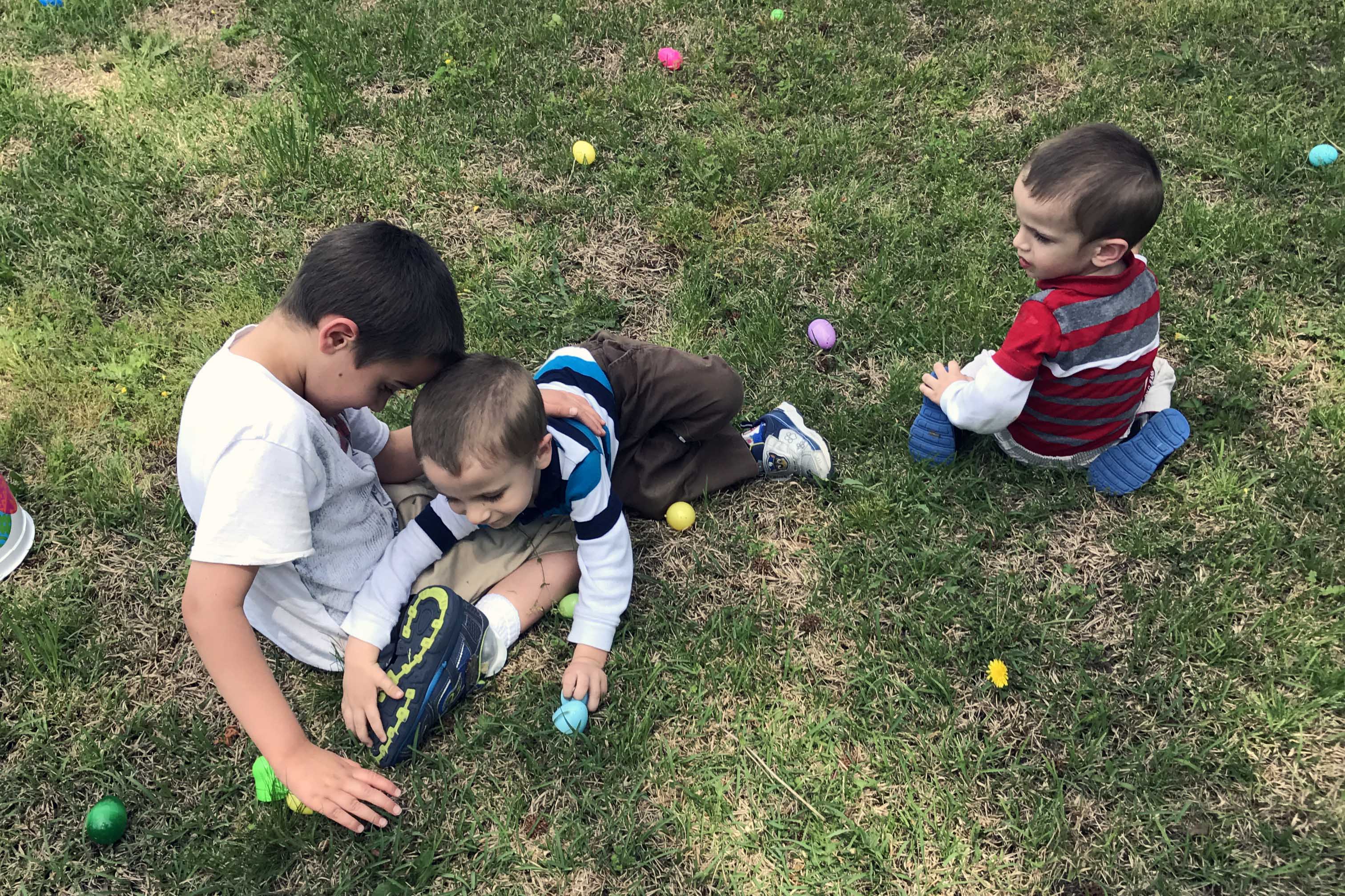 boys hunting for easter eggs on lawn