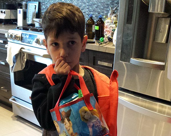 Spiro holding his lunch bag in the kitchen