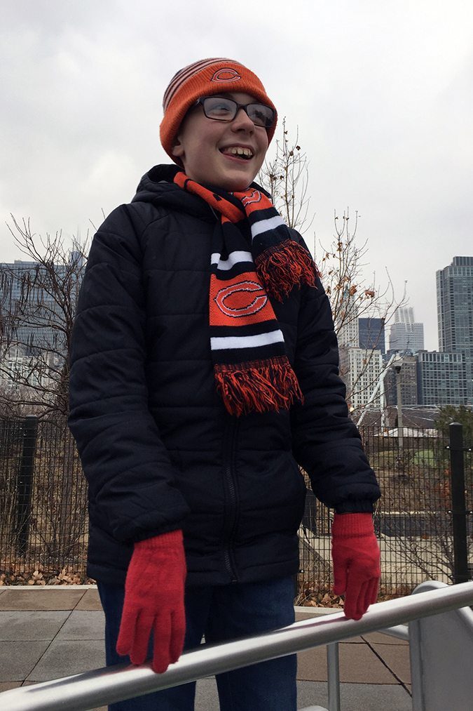 Benny Smiling in Winter Clothes standing at a railing, looking out