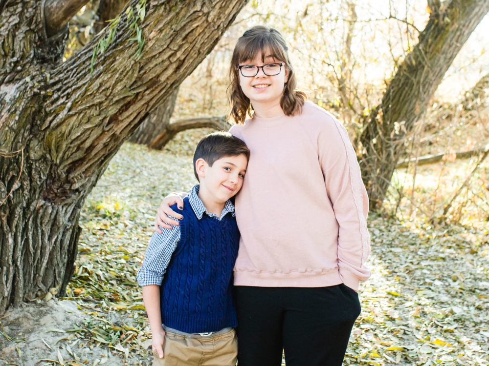 Sam and Louis hugging and smiling at the camera
