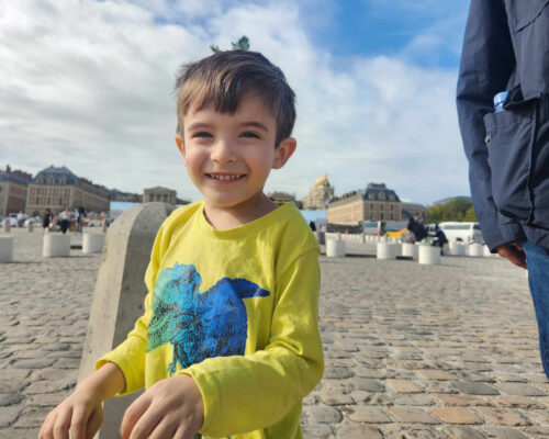 Boy smiling at the camera outside.