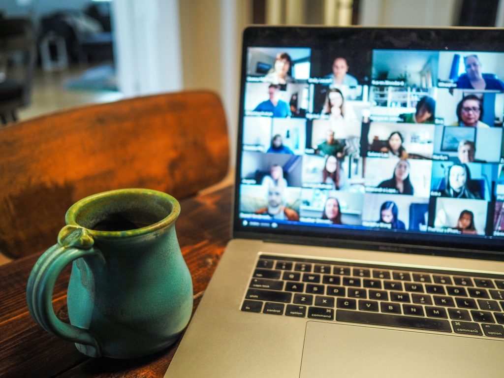 A mug next to a computer with a Zoom meeting on.